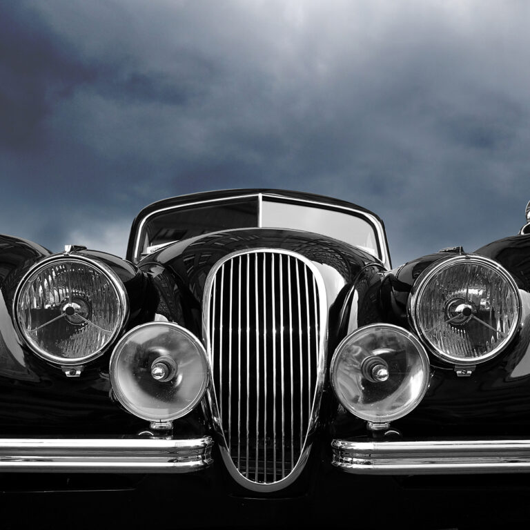 Vintage classic car front view with dark clouds